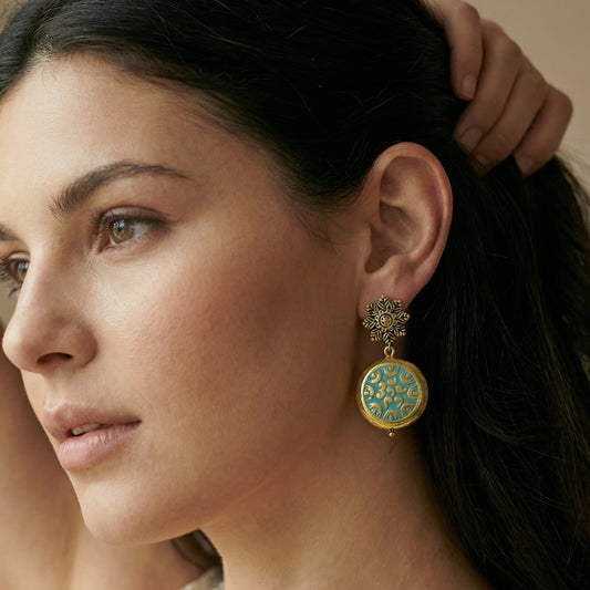 Close-up of a woman wearing a decorative earring with intricate design.