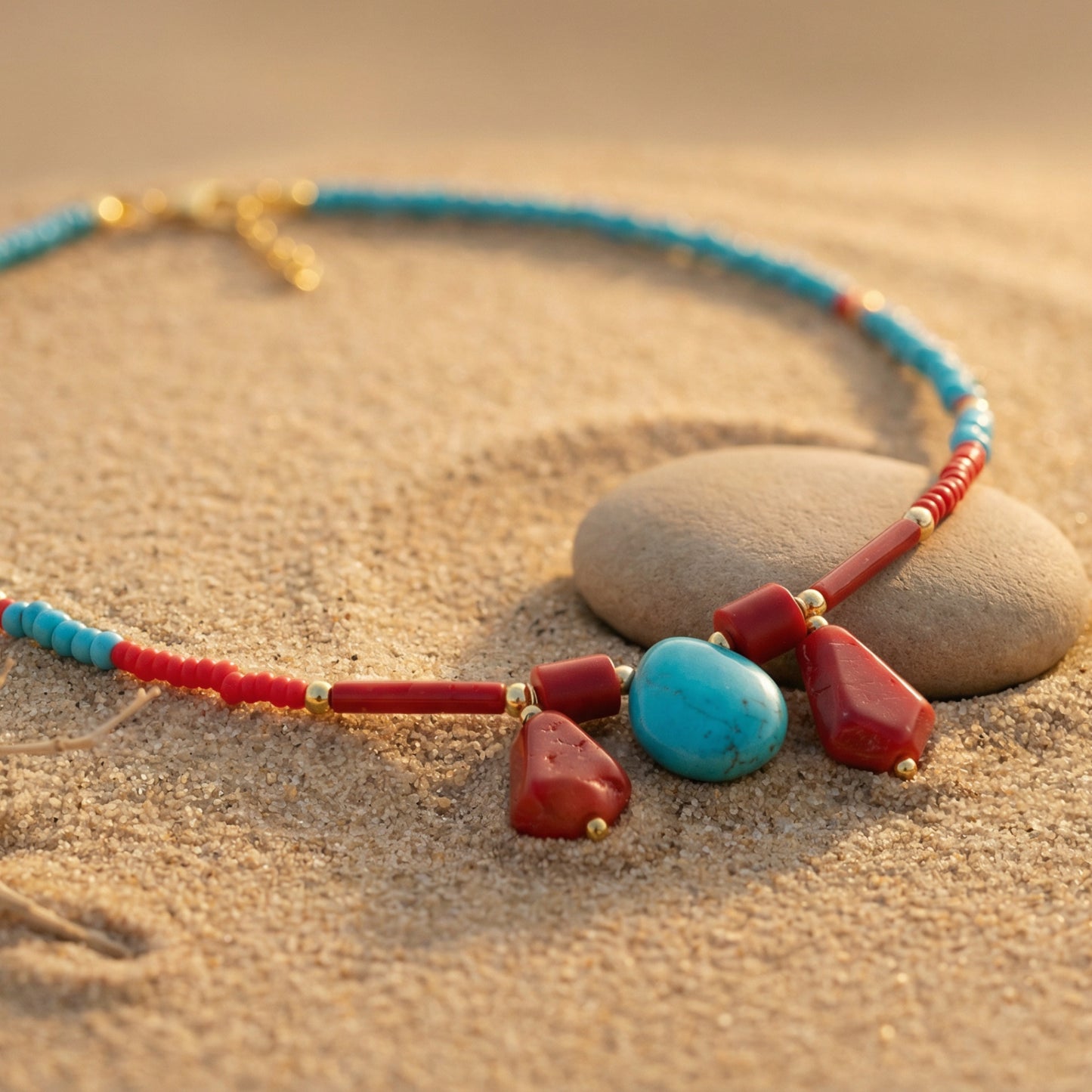 Necklace with red and blue beads on a sandy surface