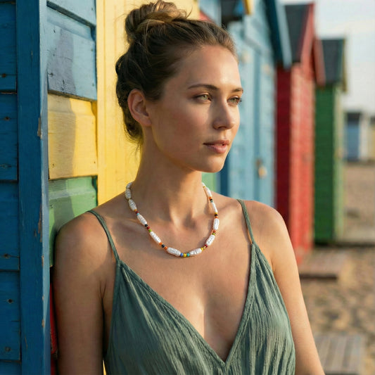 Woman in a green dress standing against colorful wooden sheds.
