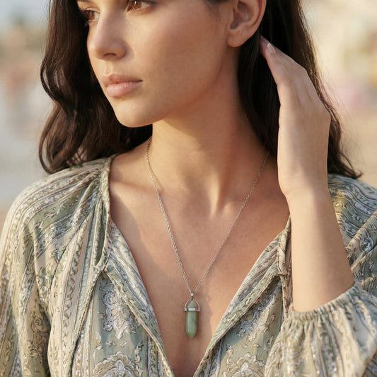 Woman wearing a necklace with a pendant outdoors