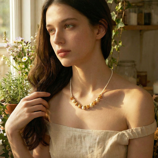 Woman wearing a necklace in a warm, indoor setting with plants