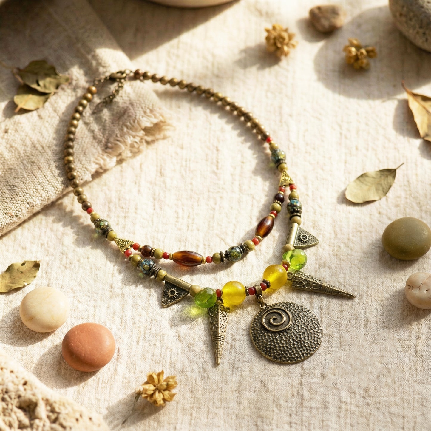 Necklace with beads and charms on a textured surface with natural elements