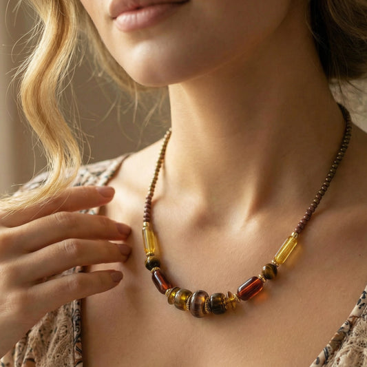 Close-up of a person wearing a beaded necklace with a neutral background