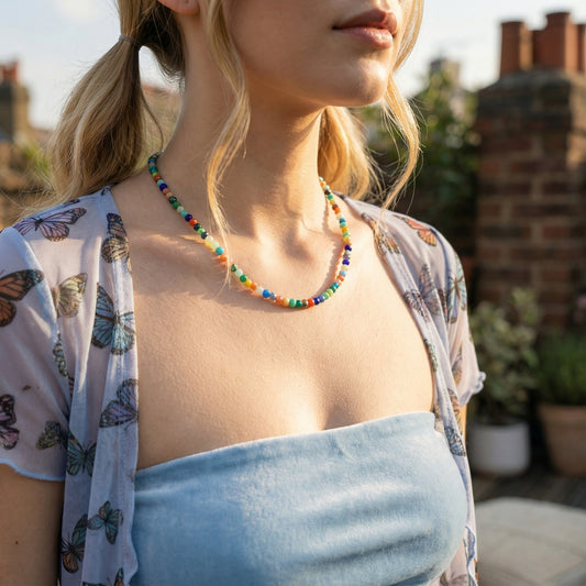 Woman wearing a colorful beaded necklace with a blurred outdoor background