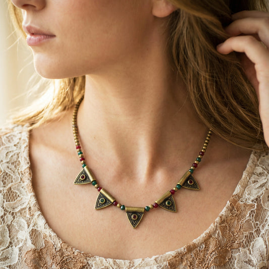 Close-up of a woman wearing a decorative necklace with geometric designs.