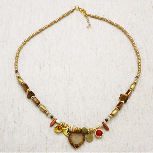 Necklace with beads and charms on a textured white background