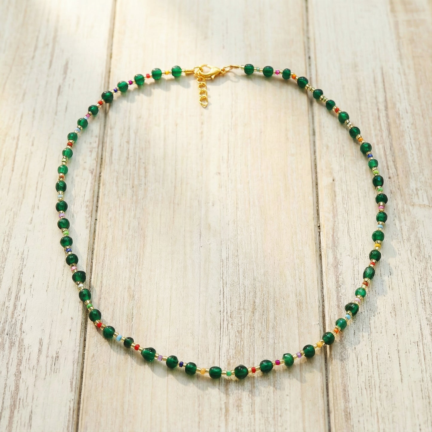 Necklace with green beads on a wooden surface