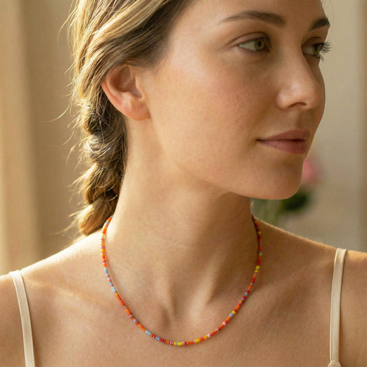 Woman wearing a colorful beaded necklace with a blurred background