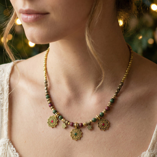 Close-up of a person wearing a decorative necklace with beads and gold pendants.