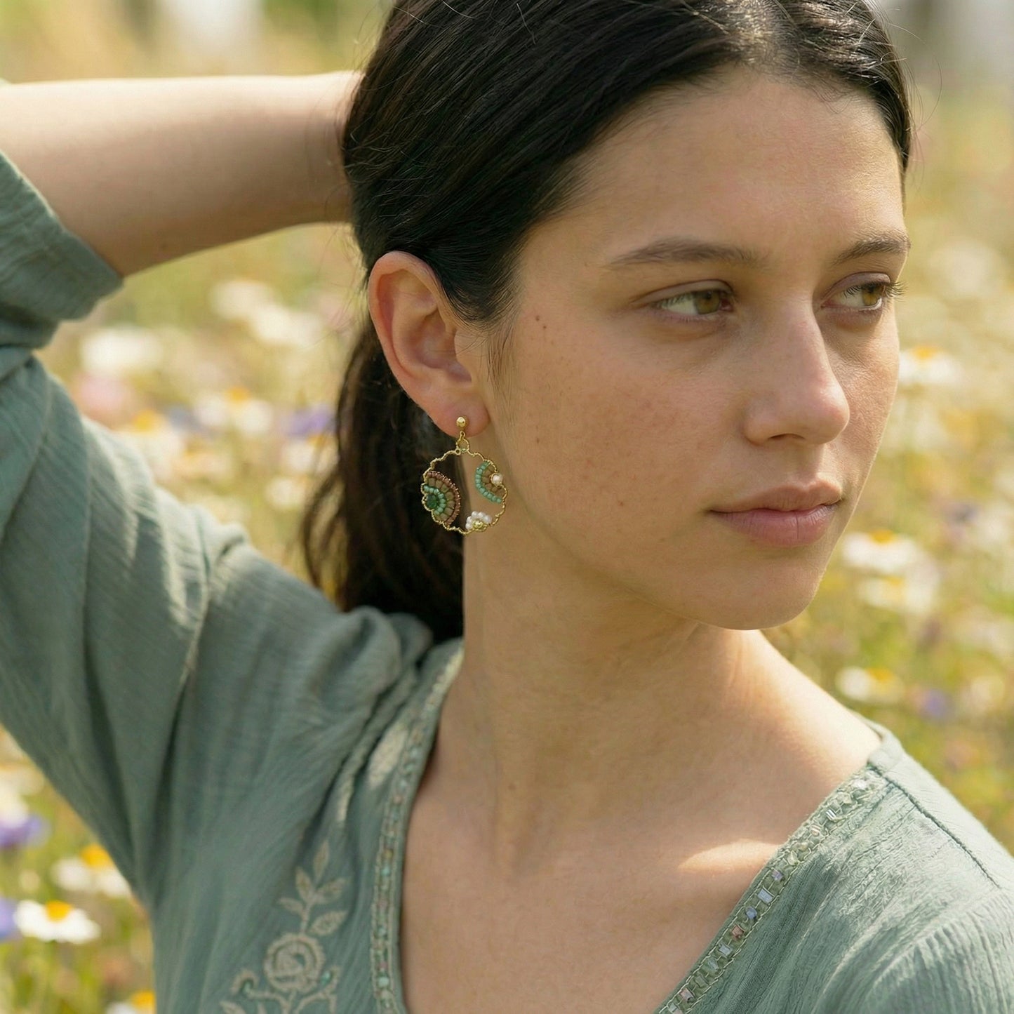 Woman wearing earrings with a blurred natural background