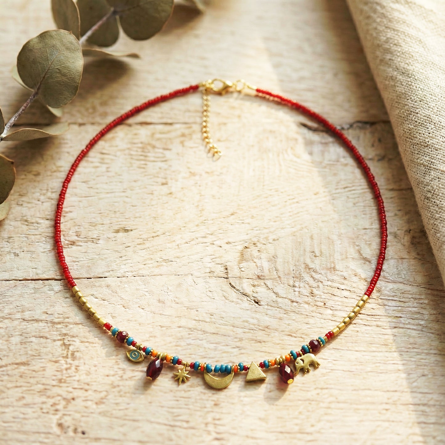 Necklace with colorful beads and gold accents on a wooden surface
