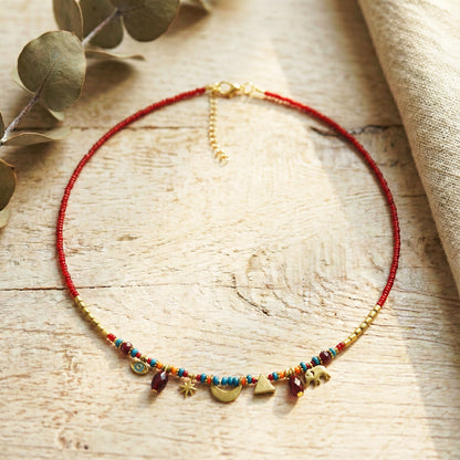 Necklace with colorful beads and gold accents on a wooden surface