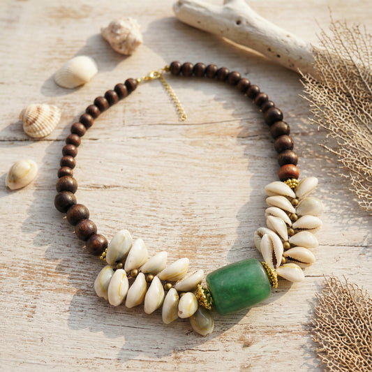 Necklace with wooden and shell beads on a wooden surface with shells and driftwood.