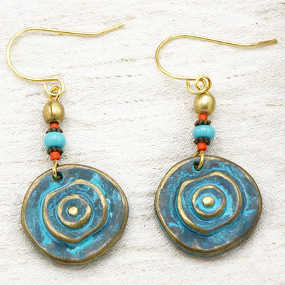 Pair of blue and gold spiral earrings on a textured white background