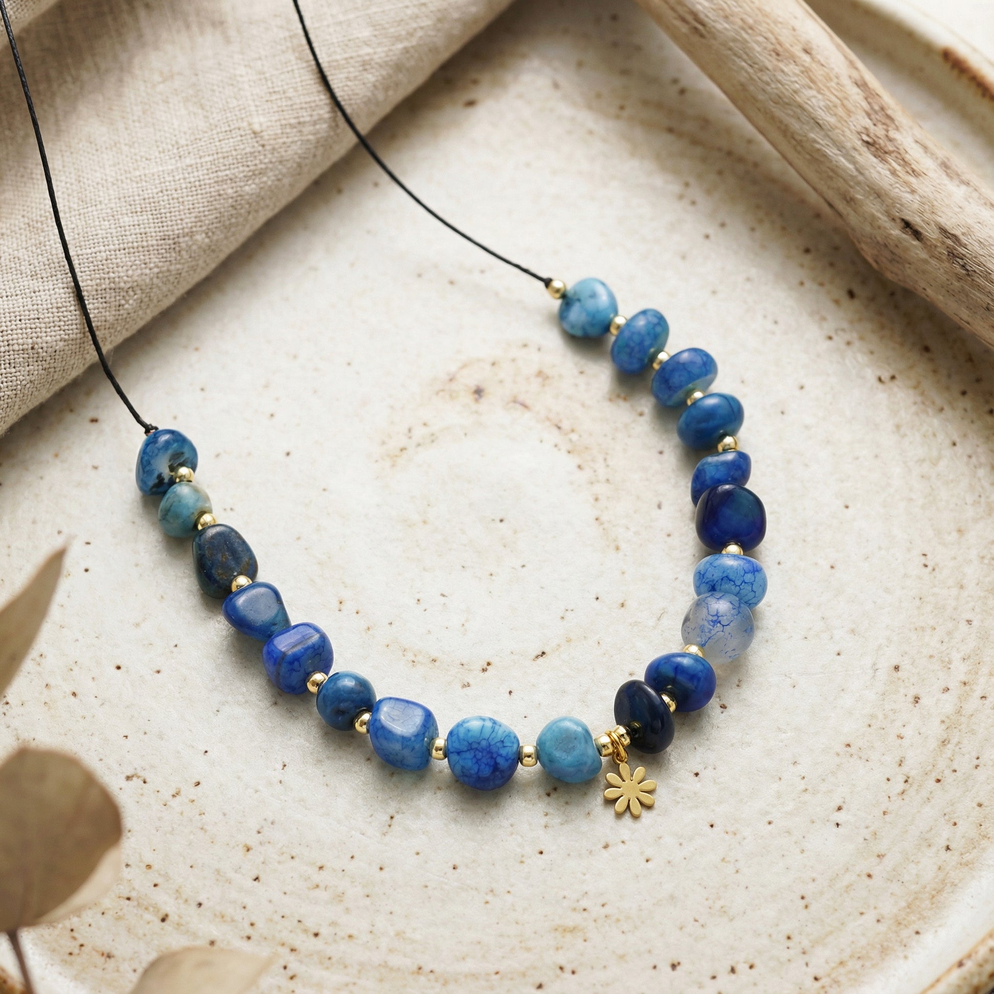 Necklace with blue beads on a textured surface