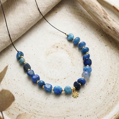 Necklace with blue beads on a textured surface