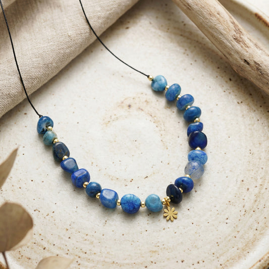 Necklace with blue beads on a textured surface