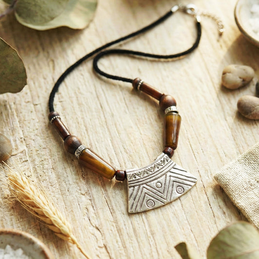 Necklace with tribal pendant on a wooden surface