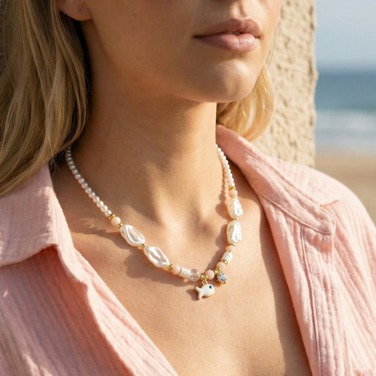 Woman wearing a pearl necklace with a blurred beach background