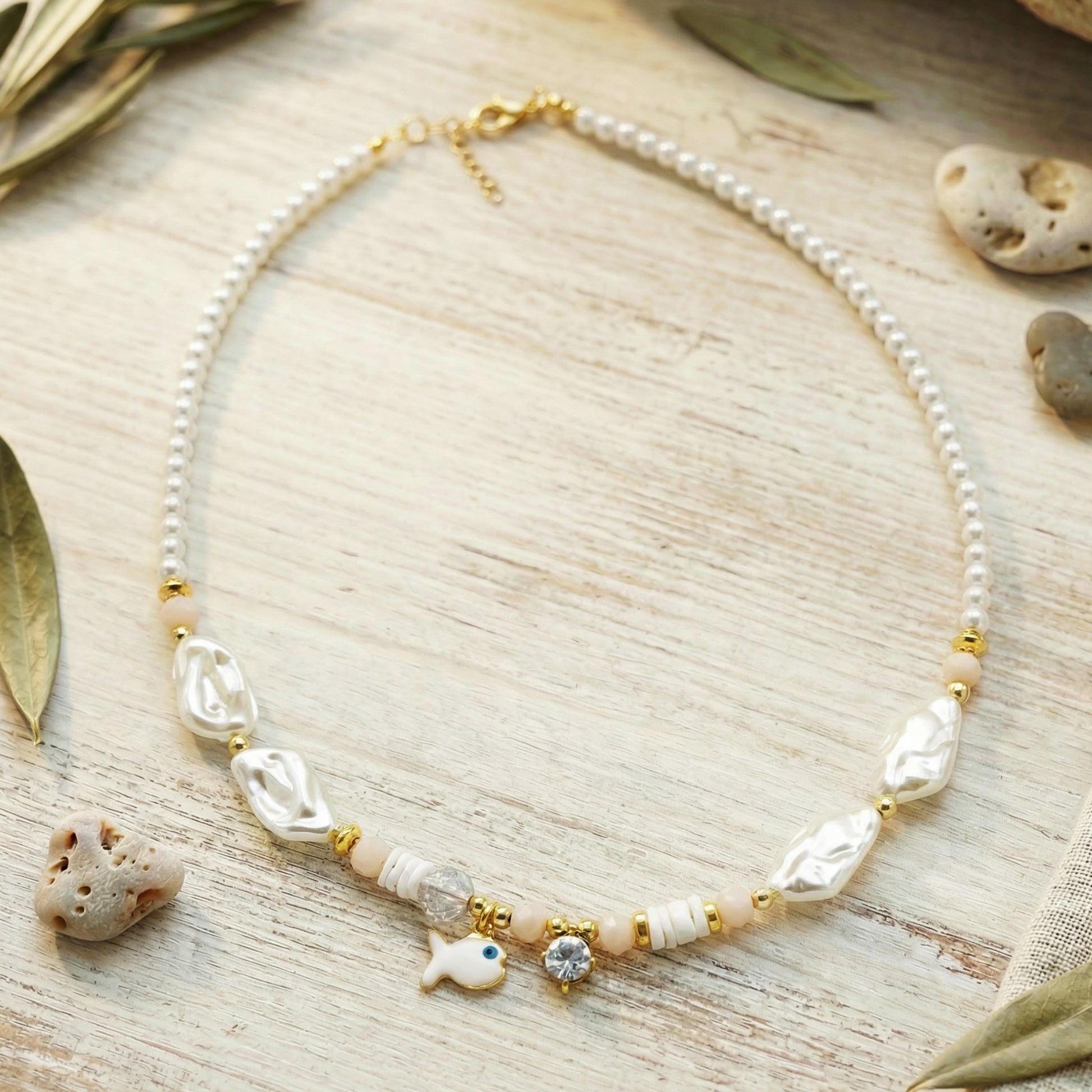 Necklace with pearls and shell-like beads on a wooden surface