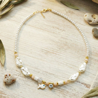 Necklace with pearls and shell-like beads on a wooden surface