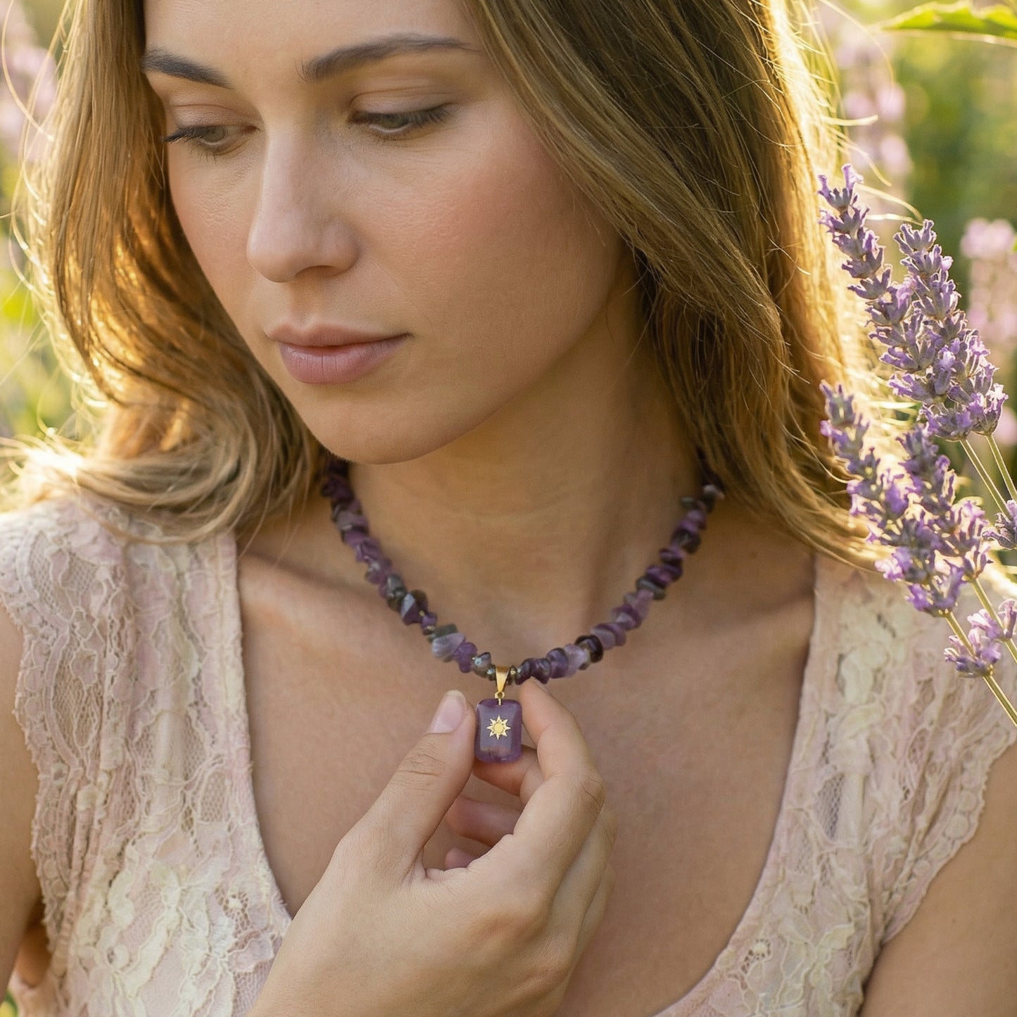 Woman wearing a purple beaded necklace with a pendant, standing in a field of lavender.