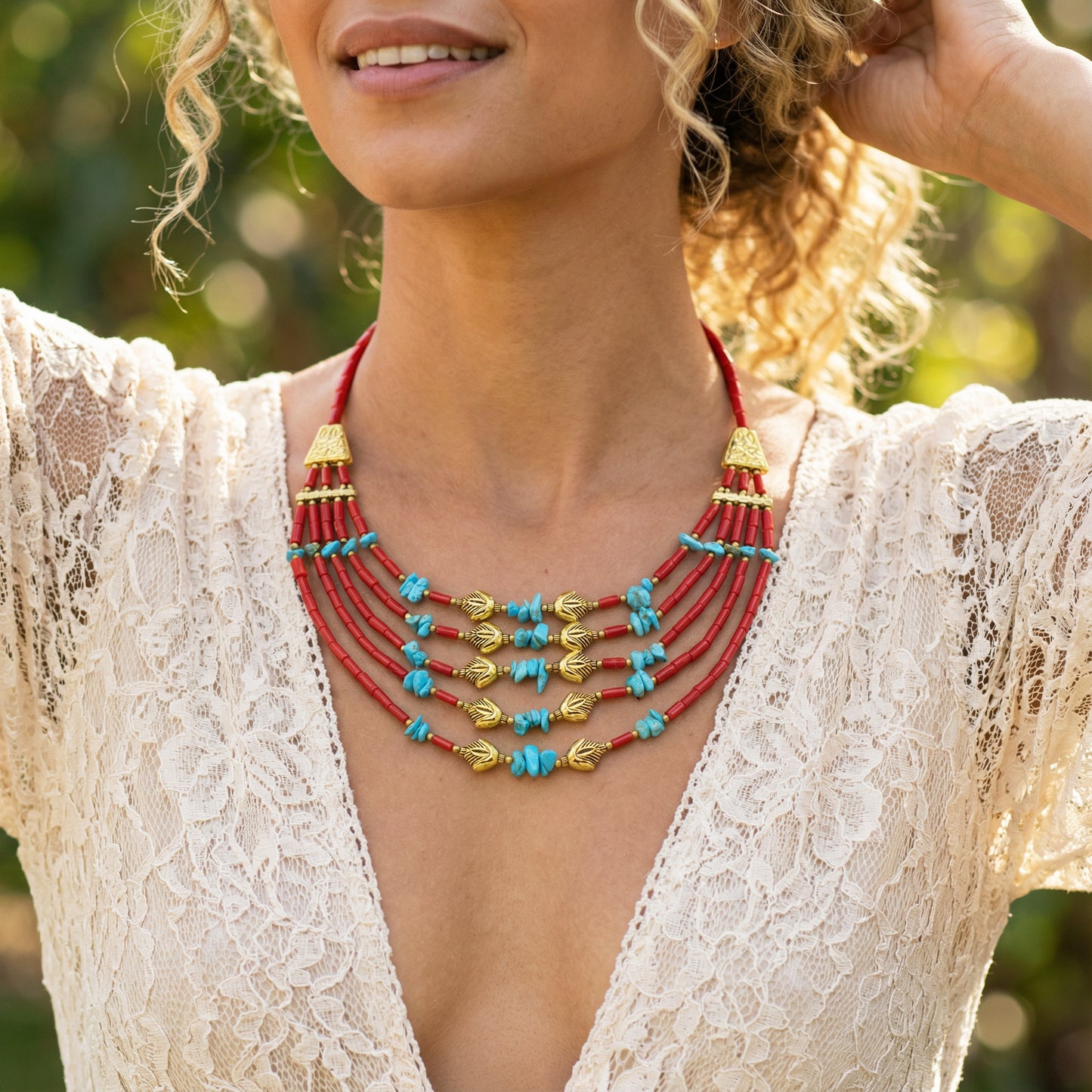 Woman wearing a colorful beaded necklace with a blurred natural background