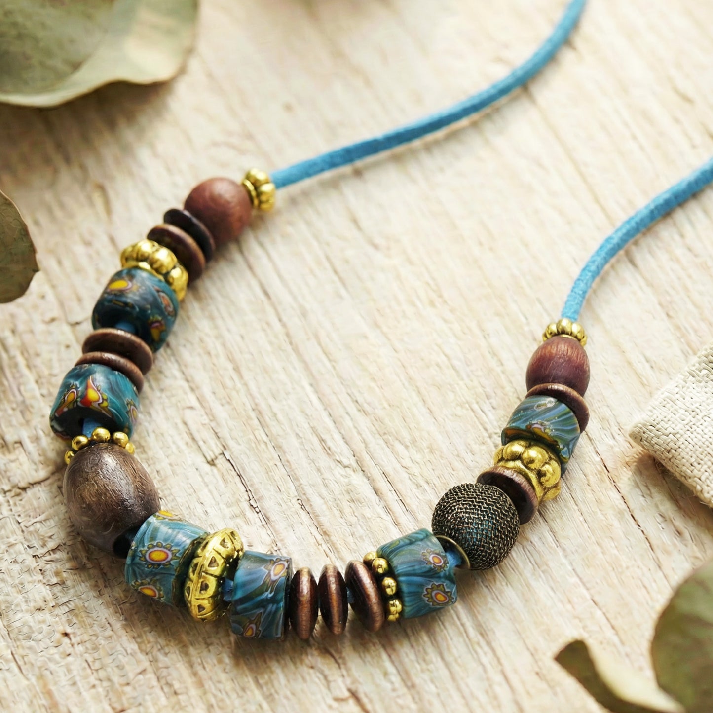 Necklace with blue and brown beads on a wooden surface