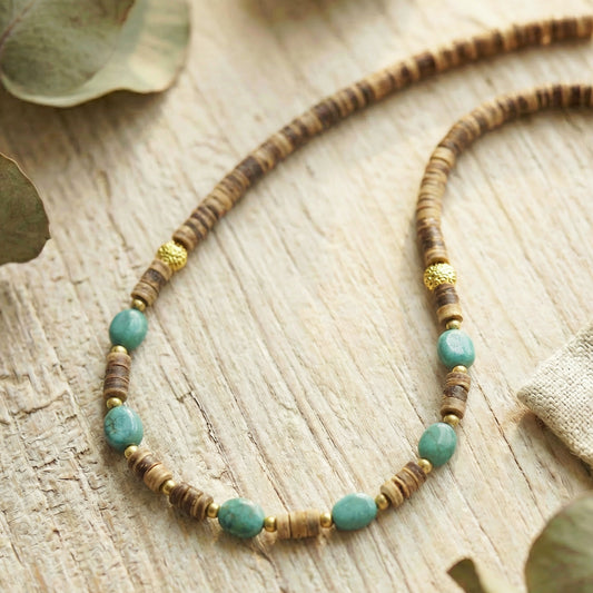 Necklace with turquoise and brown beads on a wooden surface