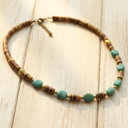 Necklace with brown and turquoise beads on a wooden surface