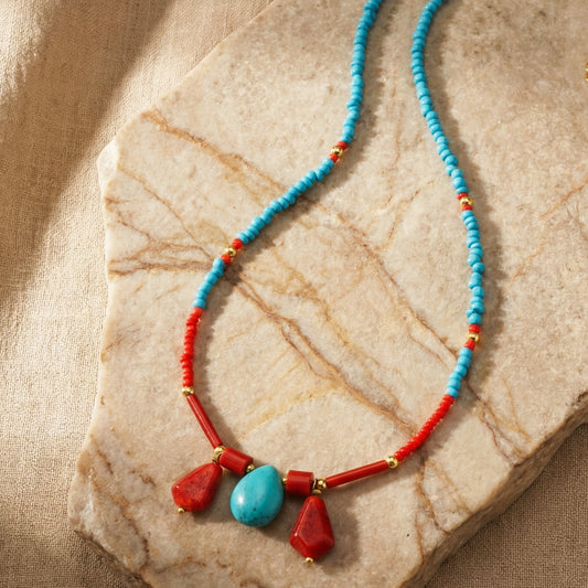 Necklace with blue and red beads on a stone surface