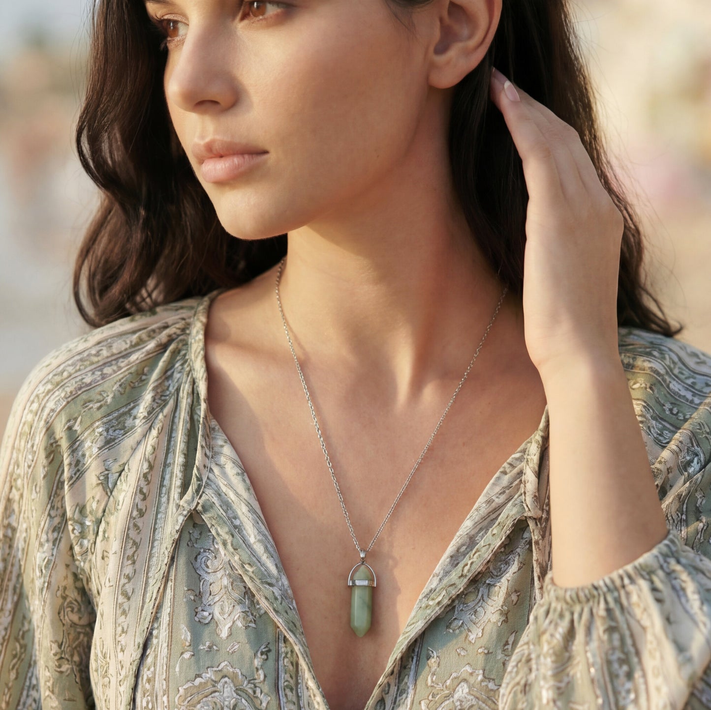 Woman wearing a necklace with a pendant outdoors