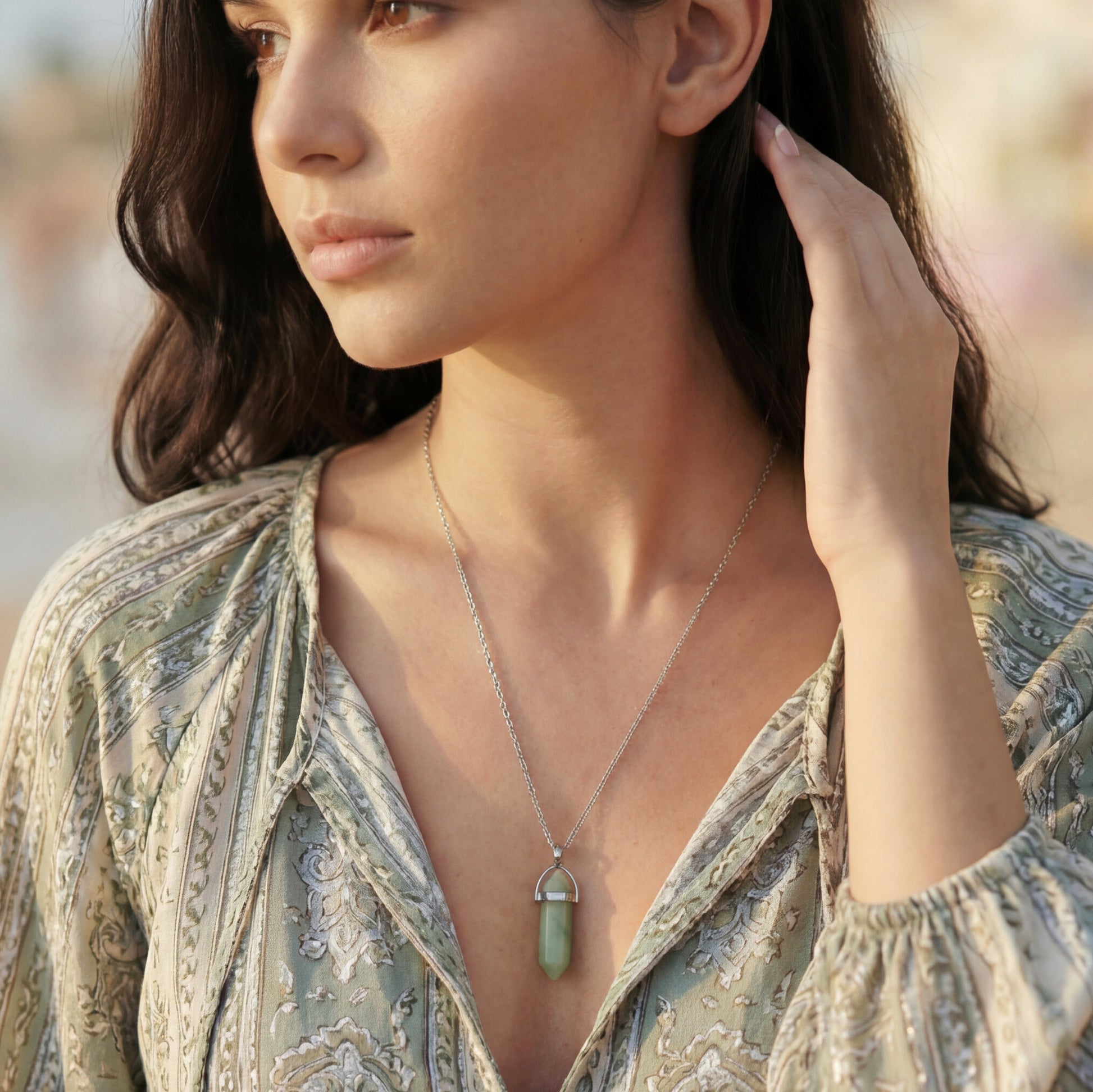 Woman wearing a necklace with a pendant outdoors