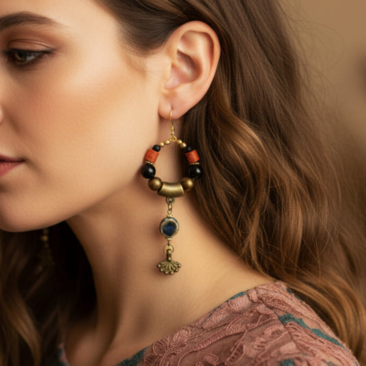 Close-up of a woman wearing a decorative earring with beads and gold accents.