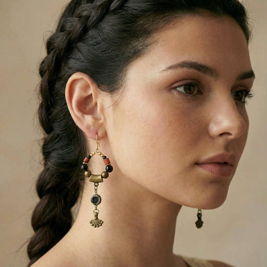 Close-up of a woman wearing a pair of earrings with a braided hairstyle.
