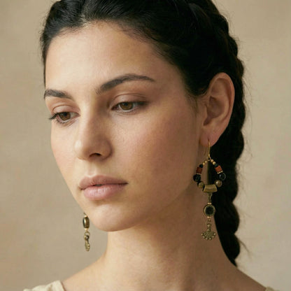 Close-up of a woman wearing gold earrings with a neutral background