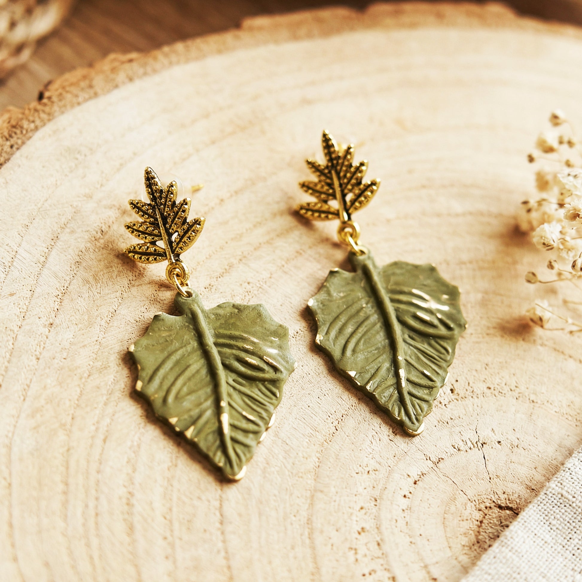 Pair of leaf-shaped earrings on a wooden surface