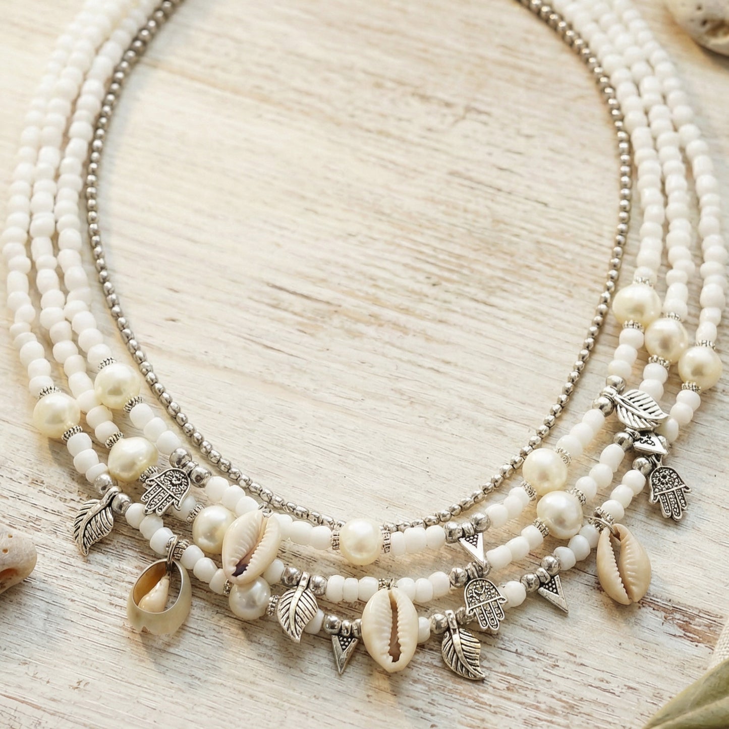 Necklace with shell and bead charms on a wooden surface