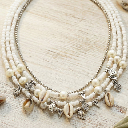 Necklace with shell and bead charms on a wooden surface
