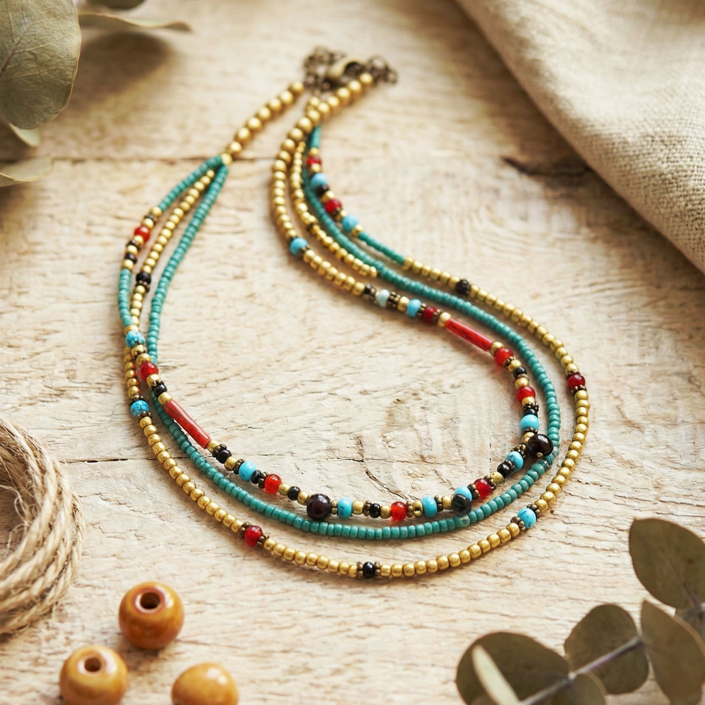 Colorful beaded necklace on a wooden surface with natural elements