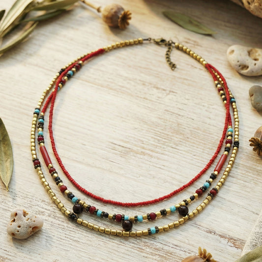 Multistrand beaded necklace on a wooden surface with natural elements.