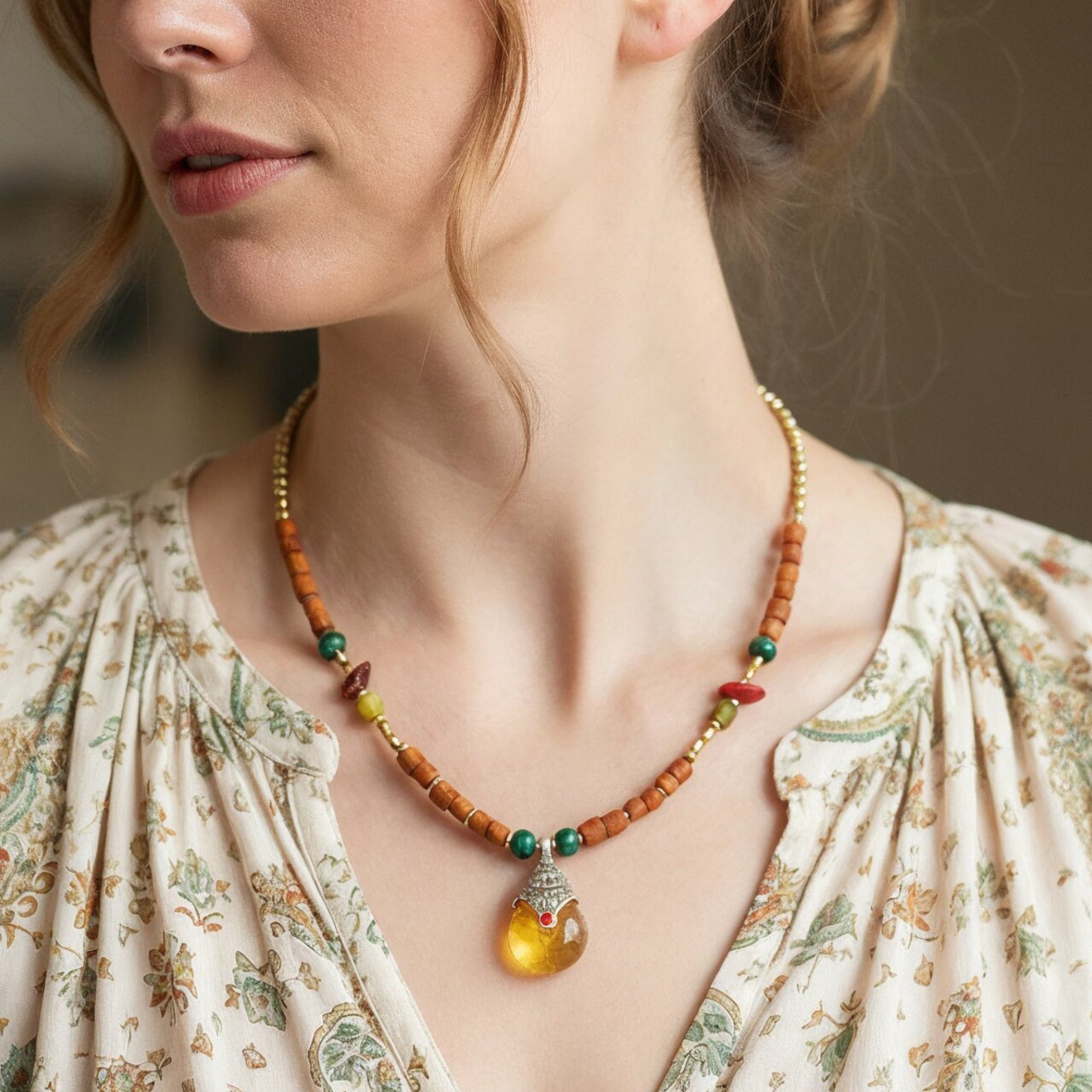 Close-up of a woman wearing a beaded necklace with a pendant.