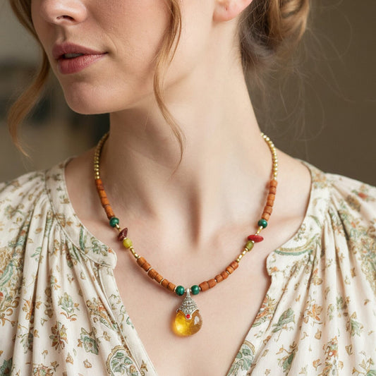 Close-up of a woman wearing a beaded necklace with a pendant.