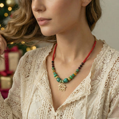 Woman wearing a colorful beaded necklace with a decorative pendant against a blurred festive background.