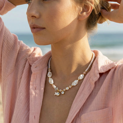 Woman wearing a pearl necklace on a beach