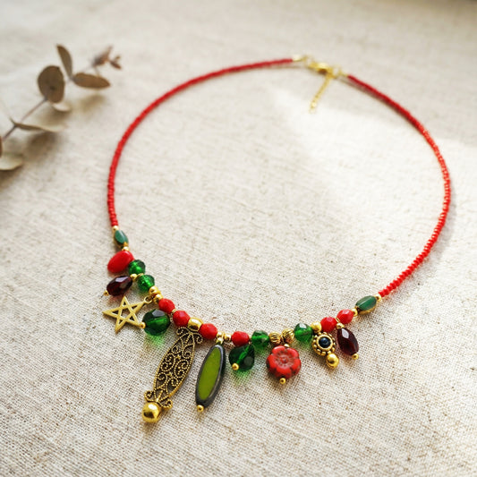 Necklace with red and green beads on a textured surface