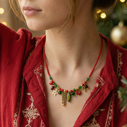 Person wearing a red beaded necklace with green and gold accents, against a blurred festive background.