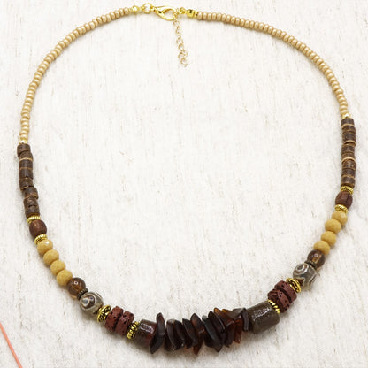 Necklace with brown and beige beads on a white background