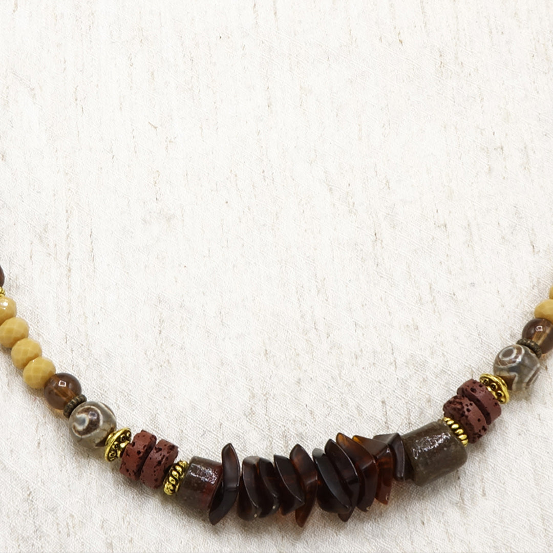 Beaded necklace with brown and beige beads on a textured white background