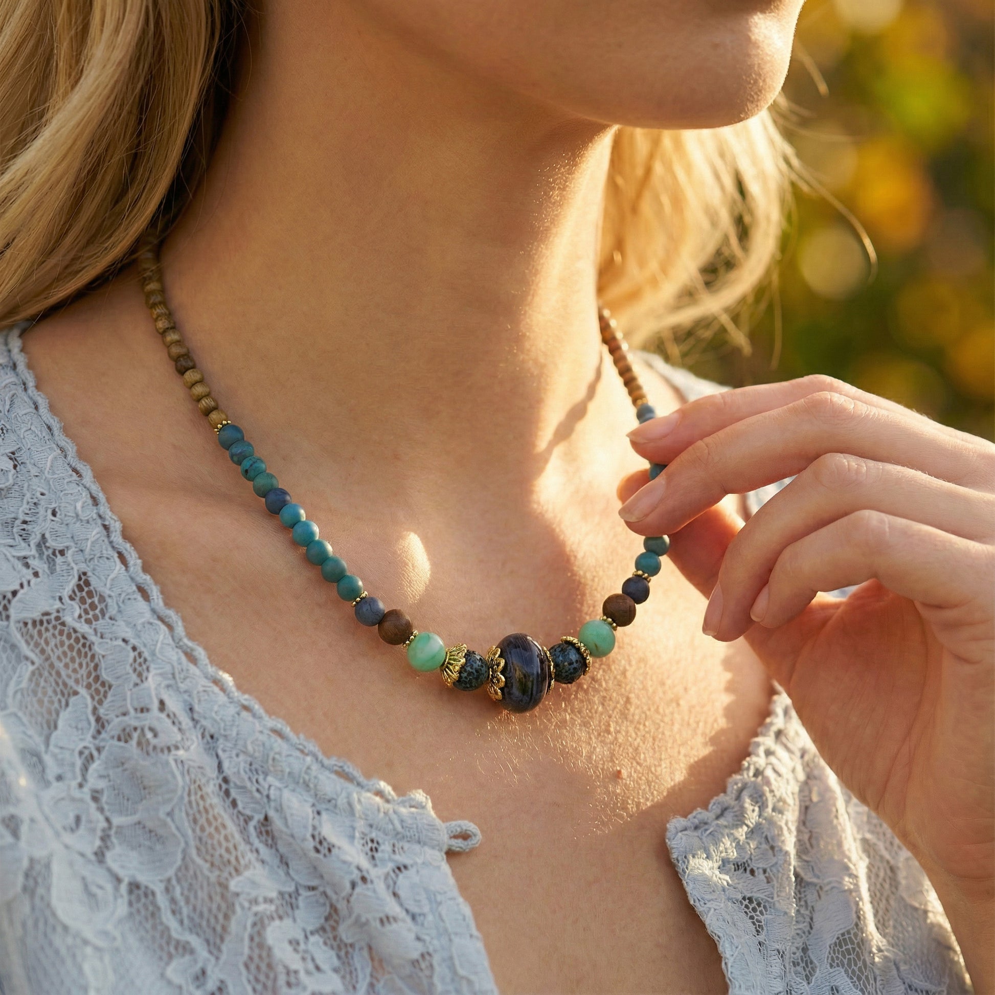 Woman wearing a beaded necklace with a blurred natural background